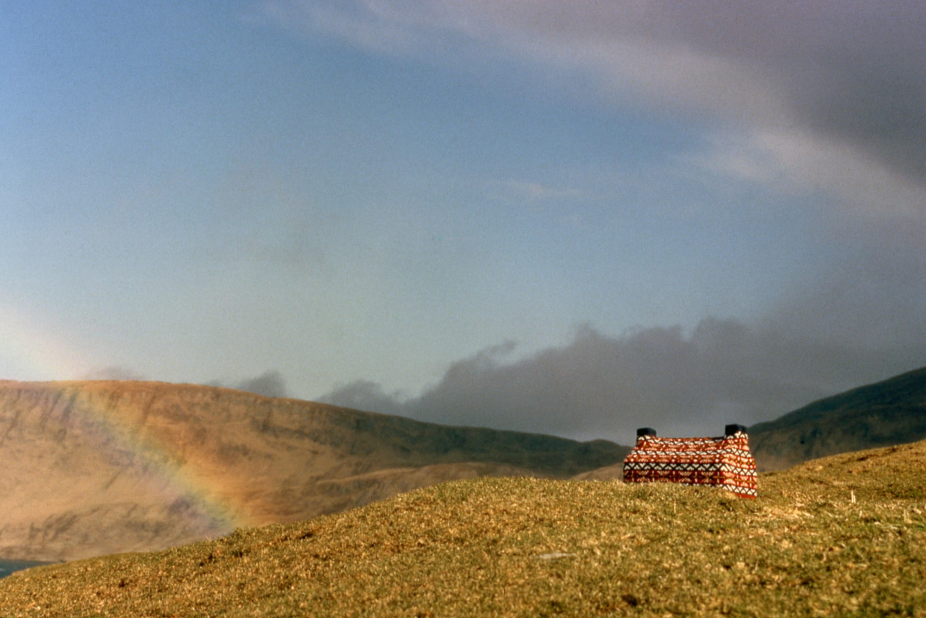 A knitted cabin in a field A knitted cabin in a field