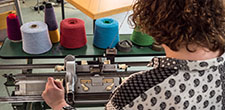 Textiles student working at knitting machine