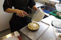 Professional Cookery student pouring cake mix