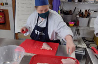 Professional Cookery student working with raw chicken