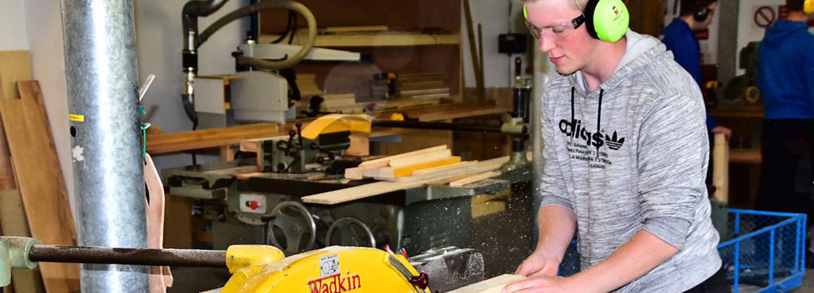 a student at a woodworking bench saw