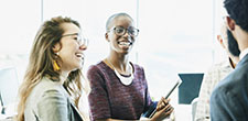 women laughing with notepad