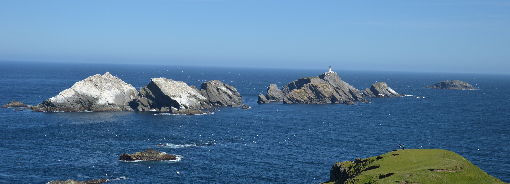 Large rocks off the coast one with a lighthouse